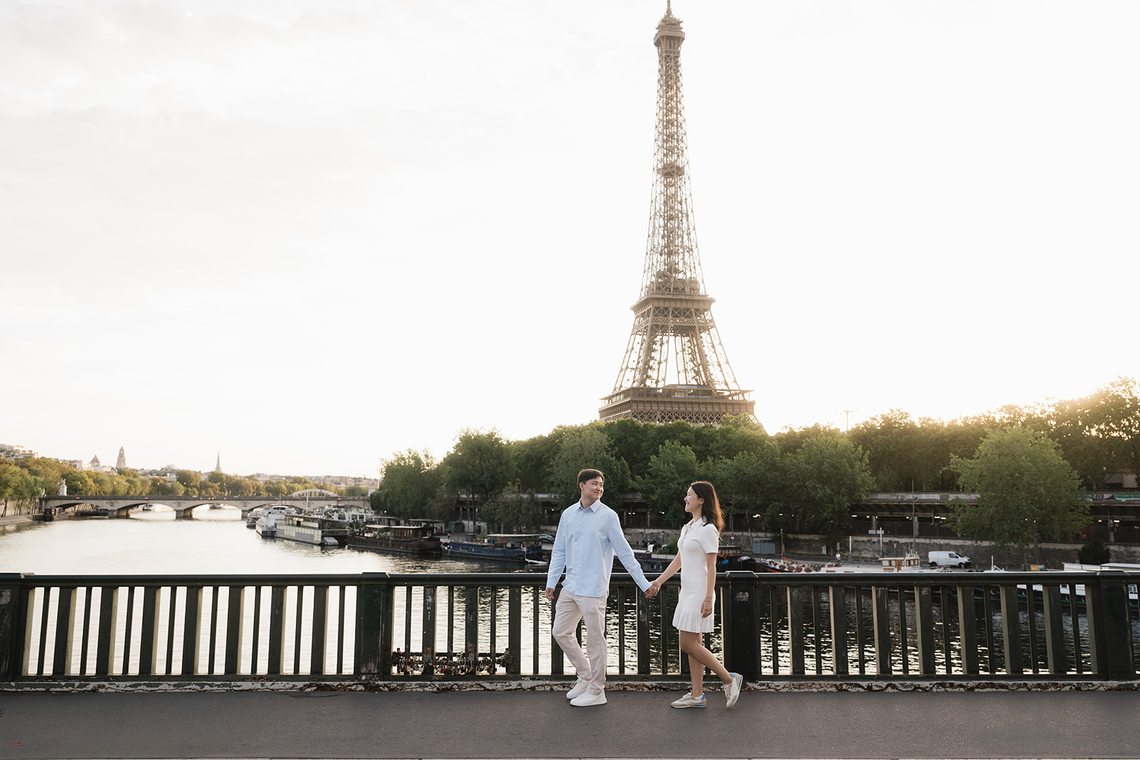 Together beside the Seine A newly engaged couple holds hands beside the Seine with the Eiffel Tower behind them.